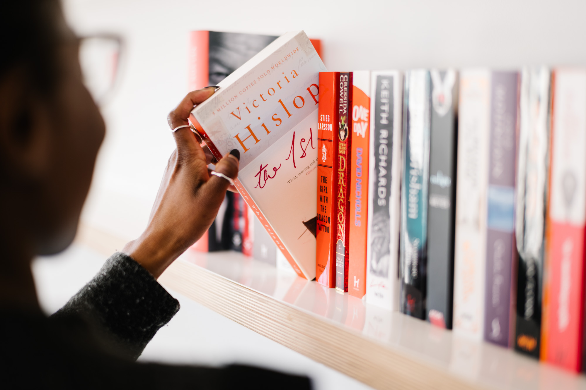 Person picking out a book.