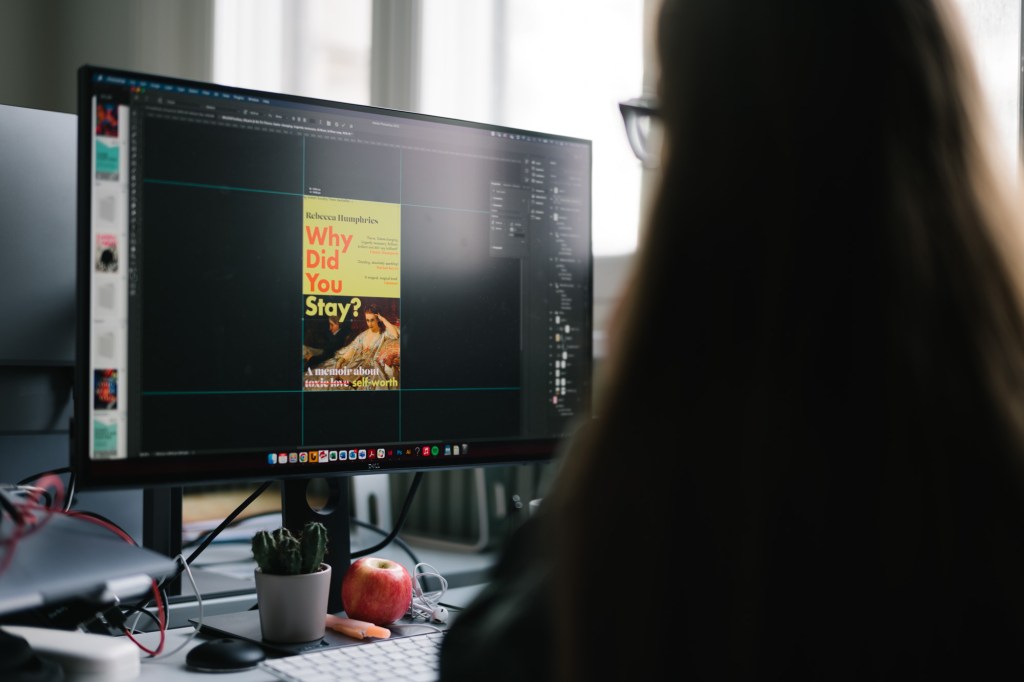 Colleague editing book cover on computer.