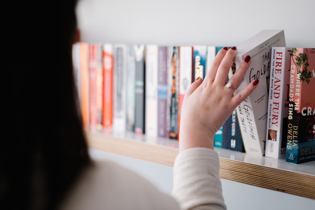 Colleague browsing bookshelf.